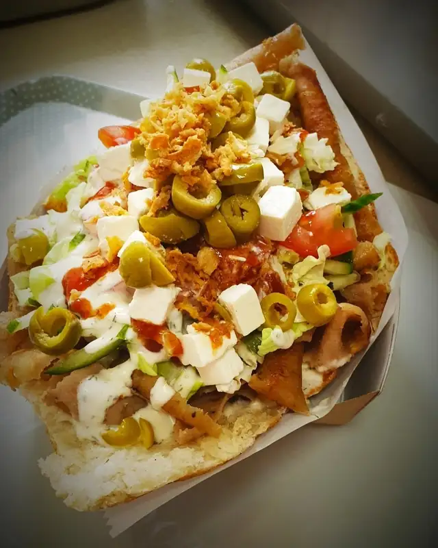 Kebab specjal na talerzu z oliwkami, fetą i surówką
